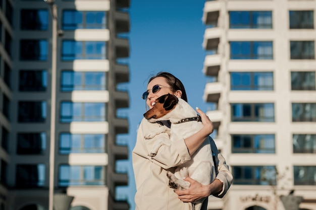 Belle fille joue avec un chien dans la rue. Amitié de l'homme avec l'animal domestique.