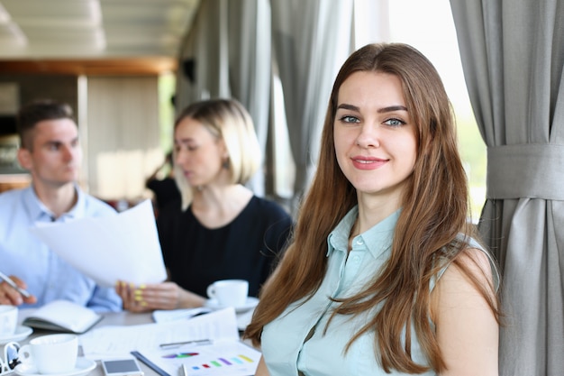 Belle fille joyeuse souriante au lieu de travail