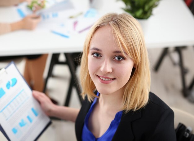 Photo belle fille joyeuse souriante sur le lieu de travail