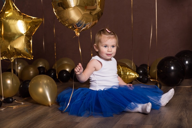 Belle fille en jupe princesse bleue avec des ballons