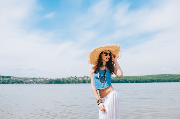 belle fille sur le lac au grand chapeau