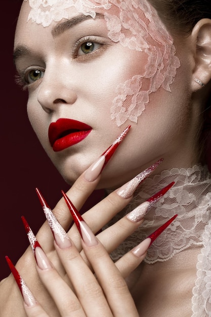 Belle fille avec des lèvres rouges en dentelle et de longs ongles