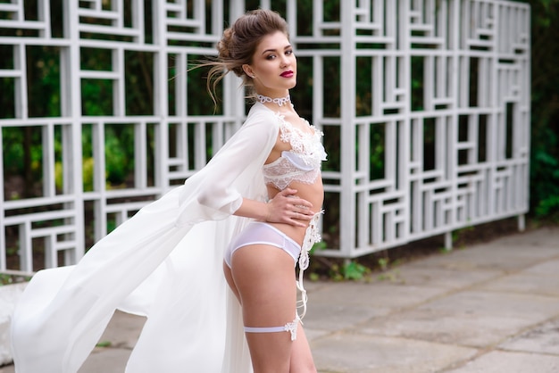 Belle fille en lingerie sexy posant sur la nature.