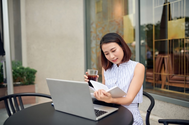 Belle fille lisant un livre dans un café