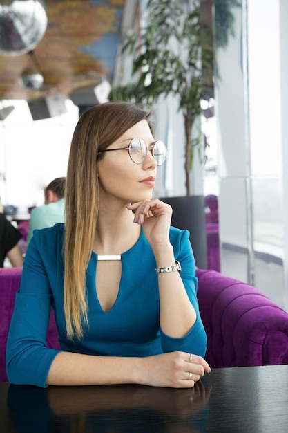 Belle fille à lunettes assise dans un café