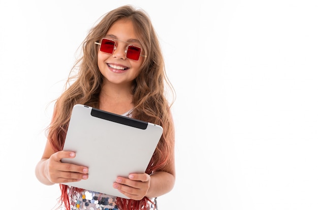 Belle fille en lunettes de soleil carrées rouges tenant une tablette grise