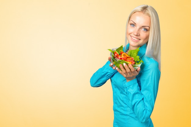 Belle fille mangeant une salade