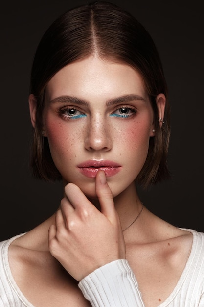 Belle fille avec un maquillage coloré créatif Visage de beauté