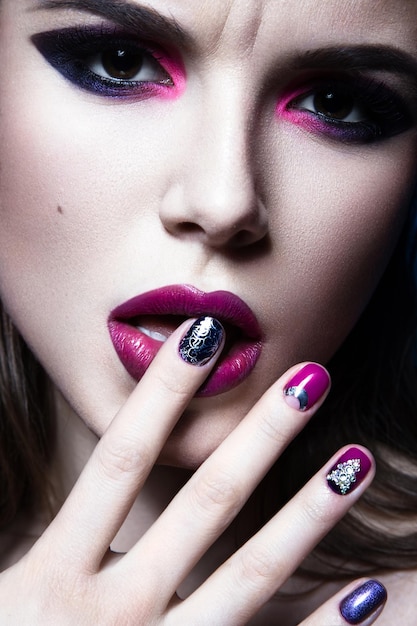 Belle fille avec un maquillage de mode créatif brillant et un vernis à ongles coloré Design de beauté artistique