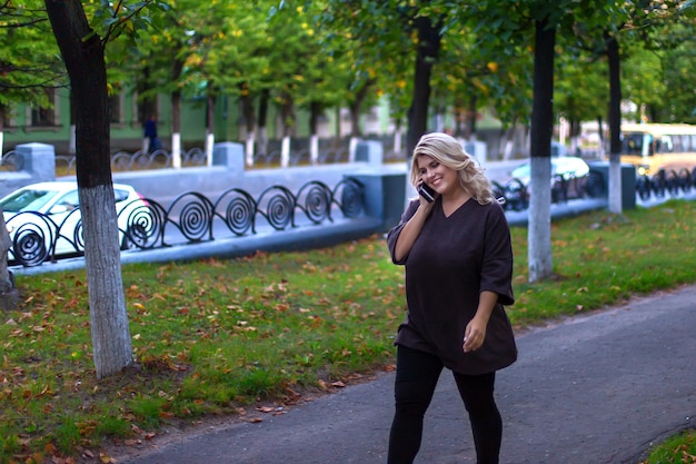 Belle fille marchant dans la rue et parlant au téléphone