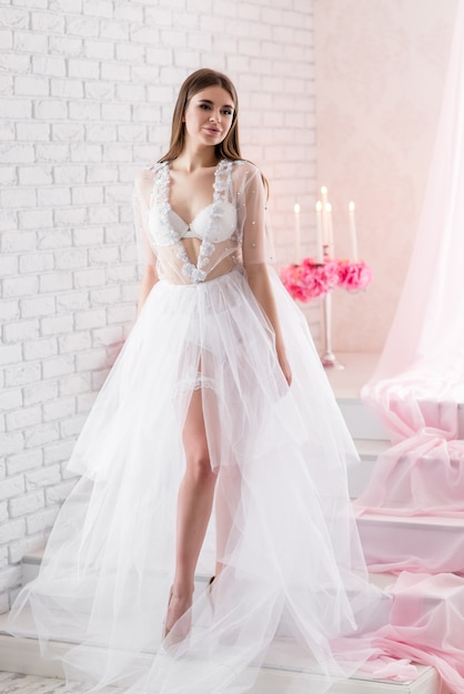 Photo belle fille mariée dans une robe boudoir en dentelle blanche en lin fermé avec un voile