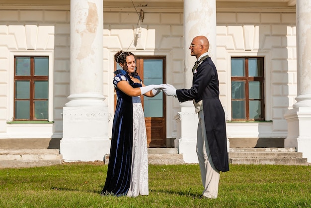 Photo belle fille avec un mec en tenue vintage sur le fond du château