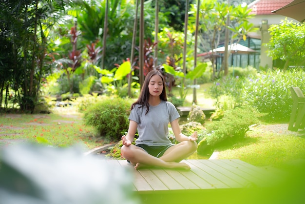 Belle fille méditant posture de yoga dans le jardin