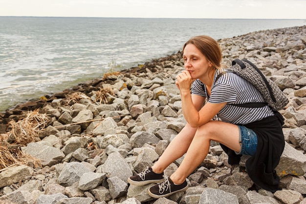 Belle fille sur la mer avec ciel bleu et nuages