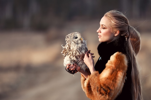 Belle fille avec la nature de cheveux longs, tenant hibou