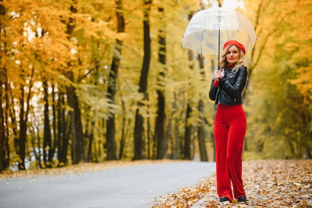 Belle fille avec parapluie au parc d'automne