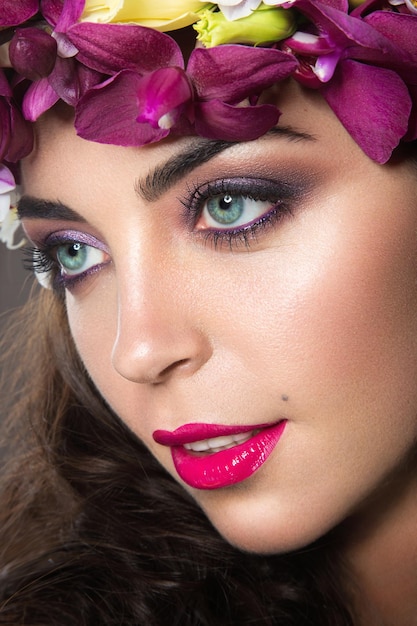 Belle fille avec une peau parfaite et une couronne florale brillante sur la tête