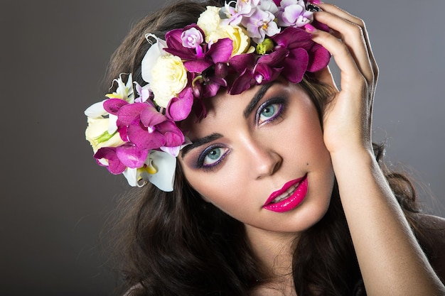 Belle fille avec une peau parfaite et une couronne florale brillante sur la tête