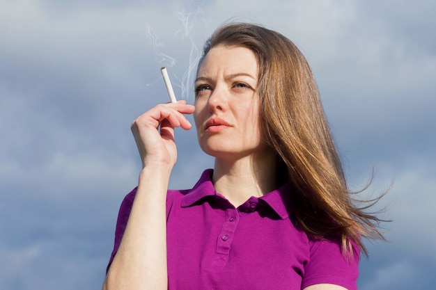 Belle fille pensive avec cigarette