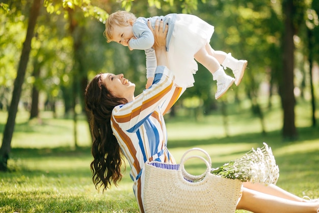 Belle fille avec une petite fille dans ses bras dans le parc