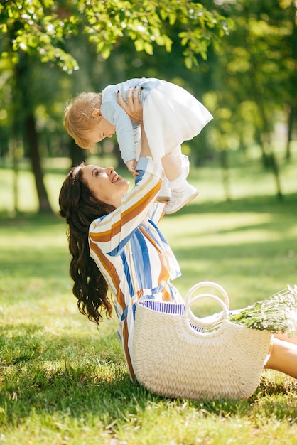 Belle fille avec une petite fille dans ses bras dans le parc