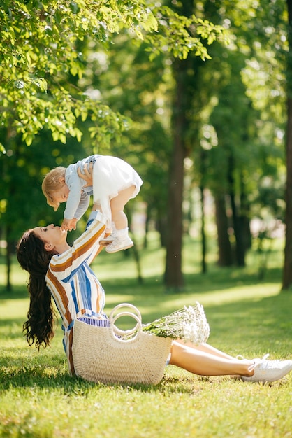 Belle fille avec une petite fille dans ses bras dans le parc