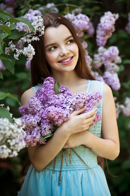 Belle fille posant dans un jardin lilas