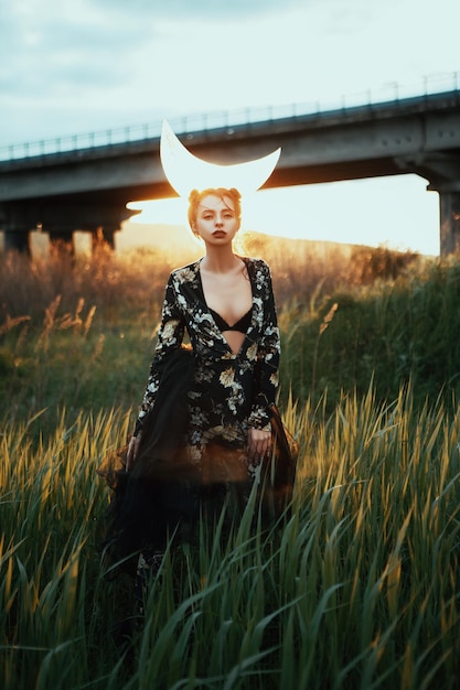 Belle fille pose ib une nature avec une lune sur la tête