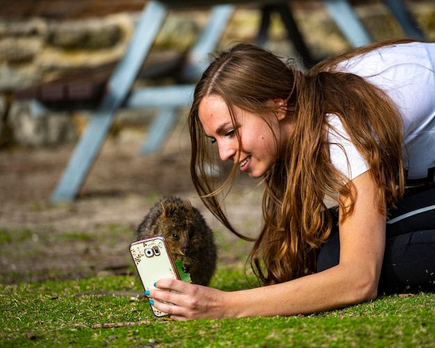 belle fille pose pour la photo avec quokka sur l'île rottenst de l'ouest de l'australie, selfie quokka
