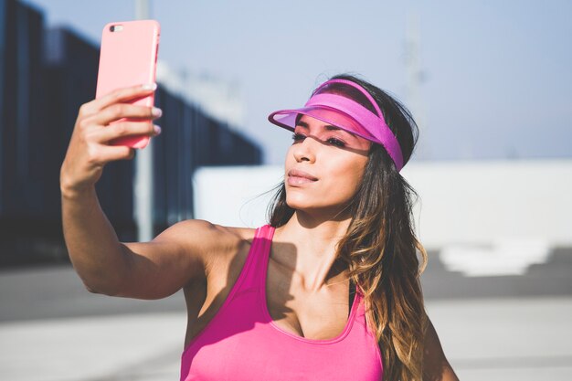 Belle fille prenant une photo de soi avec un smartphone