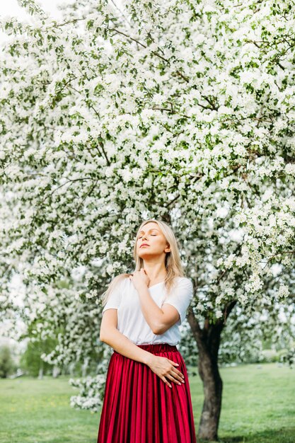 Belle fille près d'arbres en fleurs