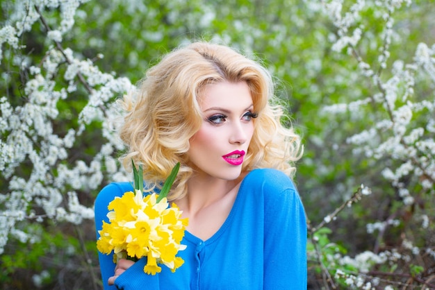 Belle fille de printemps dans un arbre en fleurs printemps visage frais jeune belle femme faire du rouge à lèvres