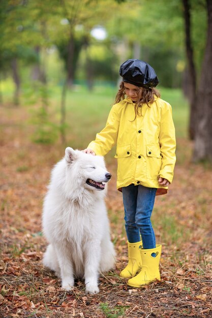 Belle fille sur une promenade avec un beau chien dans un parc en plein air