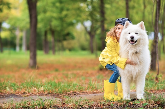 Belle fille sur une promenade avec un beau chien dans un parc en plein air