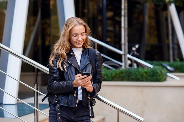 Belle fille qui marche dans la rue par une journée ensoleillée