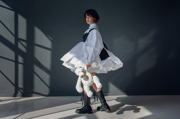 Photo une belle fille qui ressemble à une poupée dans une robe blanche