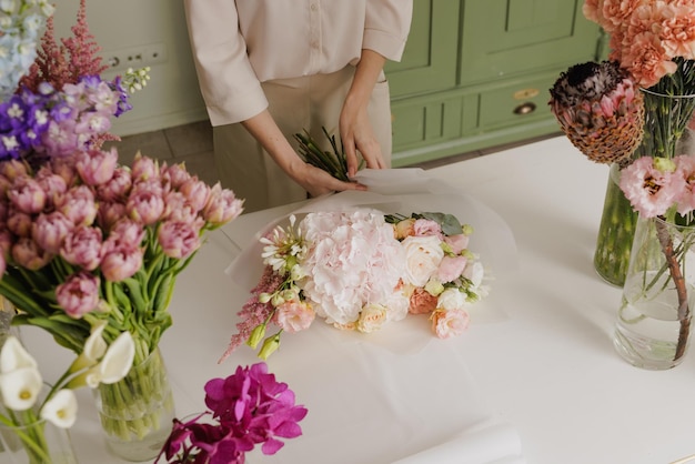 Belle fille recueille un bouquet de fleurs dans un fleuriste