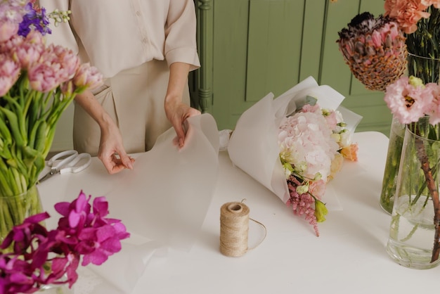 Belle fille recueille un bouquet de fleurs dans un fleuriste