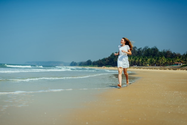 Belle fille en robe blanche Profitez et détendez-vous sur la plage