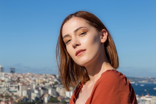 Belle fille avec une robe de couleur orange posant avec la scène d'Istanbul