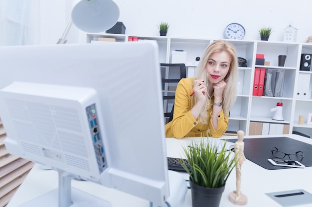 Belle fille en robe jaune travaillant sur son lieu de travail