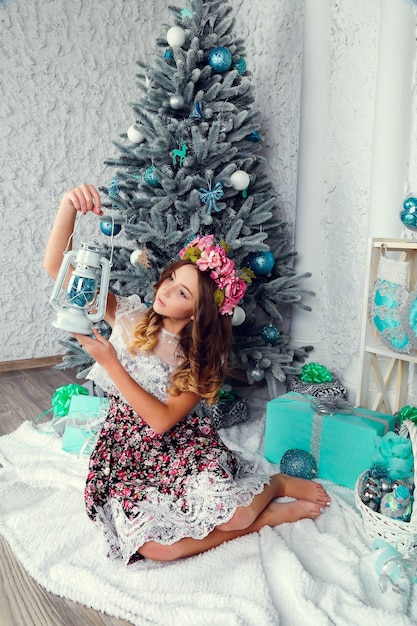 Belle fille en robe près de l'arbre de Noël