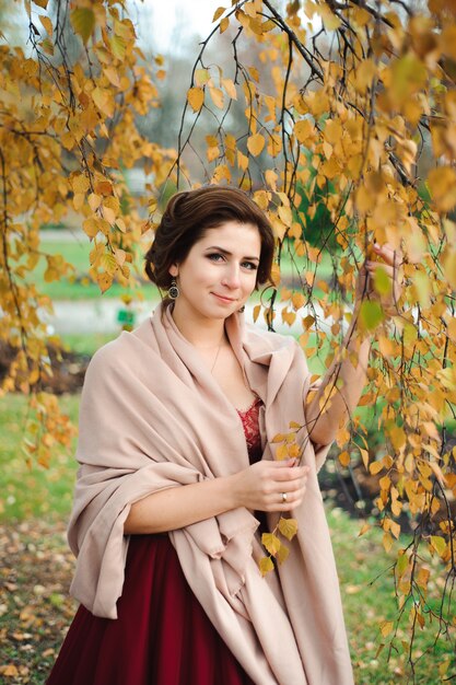 Belle fille en robe rouge dans la forêt d'automne