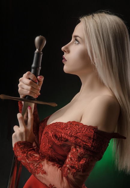 Belle fille en robe rouge avec épée