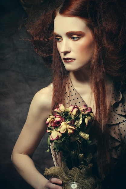 Belle fille avec des roses sèches en décoration