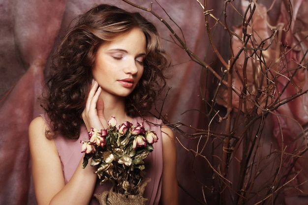 Belle fille avec des roses sèches