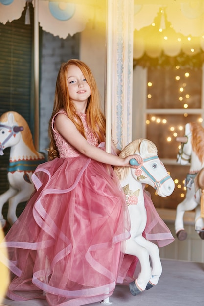 Photo belle fille rousse cheveux longs manèges carrousel