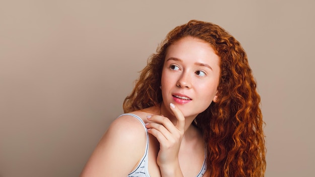 Photo belle fille rousse regarde l'espace de copie et sourit mignonne. concept de planification