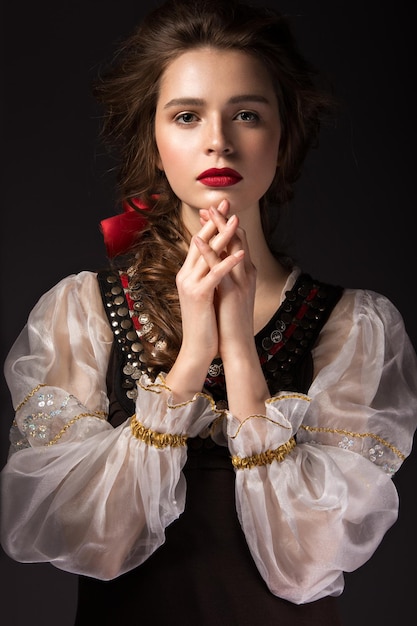 Belle fille russe en costume national avec une coiffure tressée et des lèvres rouges Visage de beauté