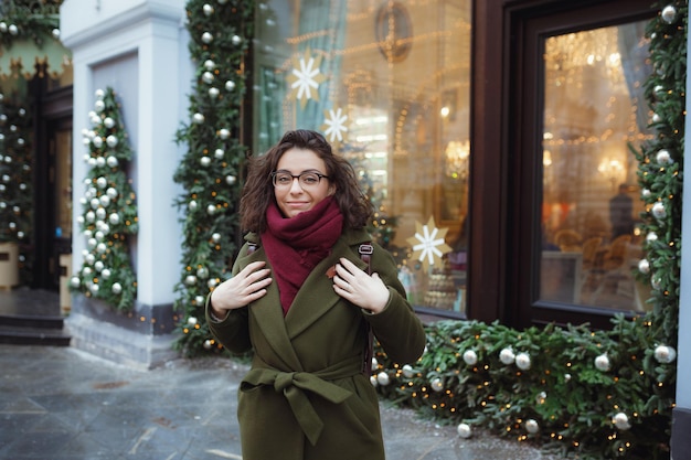 Belle fille russe dans une journée nuageuse en vêtements d'hiver s'amusant sur la place Tverskaya à Noël Mode de vie urbain Chute de neige magique Espace de copie vide pour le texte